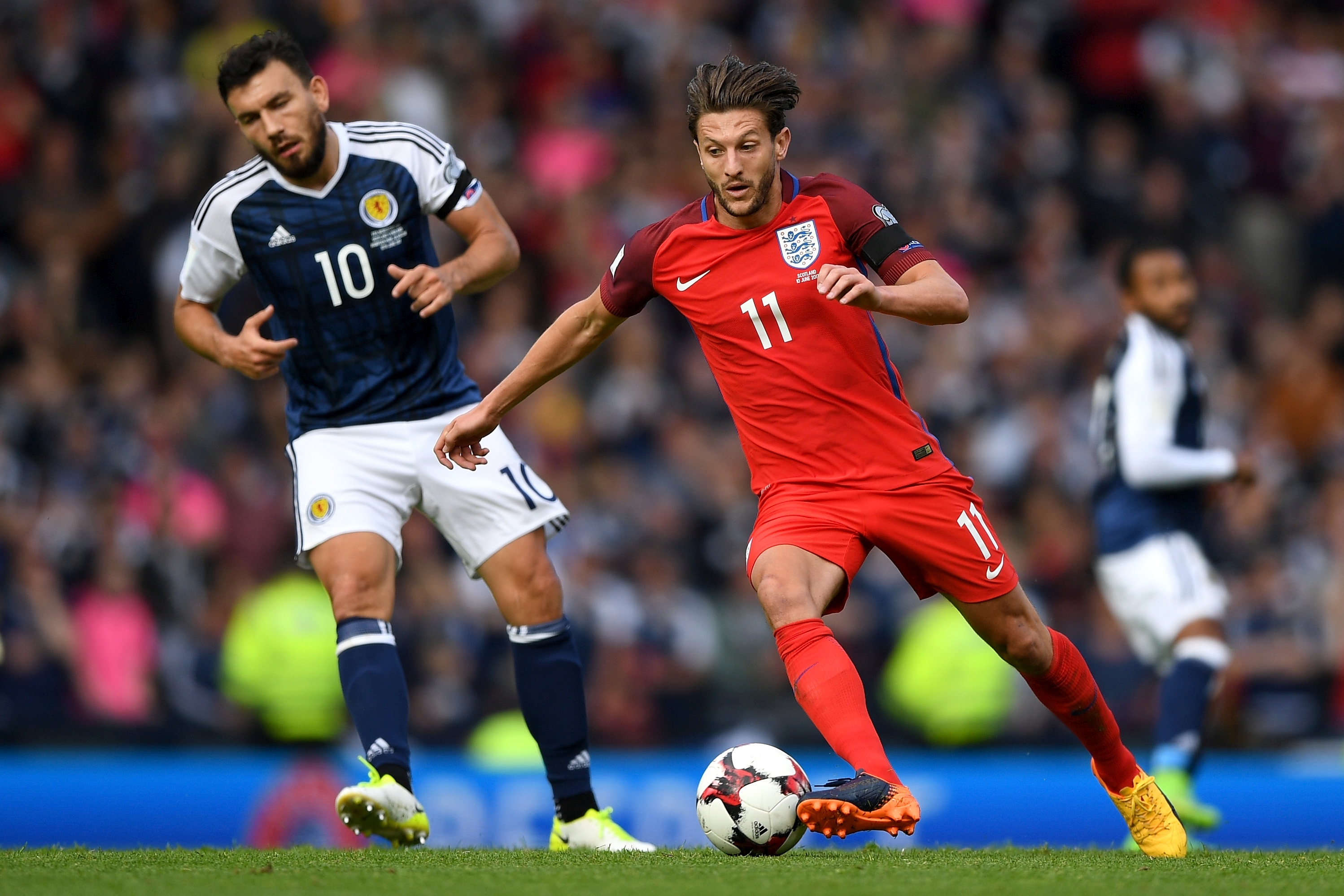 Adam Lallana of England takes the ball past Robert Snodgrass of Scotland during the FIFA 2018 World Cup Qualifier between Scotland and England at Hampden Park National Stadium on June 10, 2017 in Glasgow, Scotland. (Photo by Shaun Botterill/Getty Images)